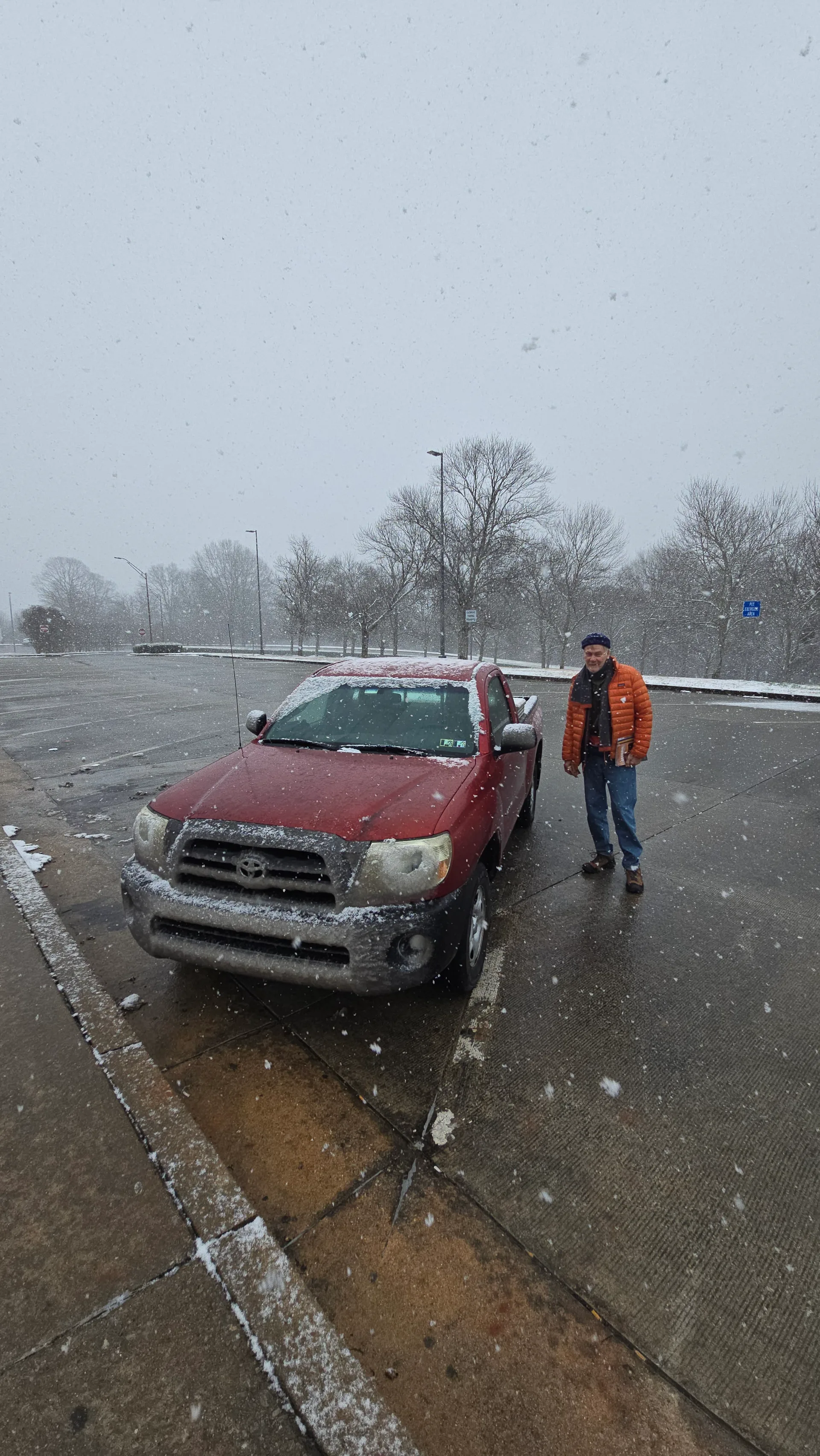 Dad standing by the snow-covered Tacoma